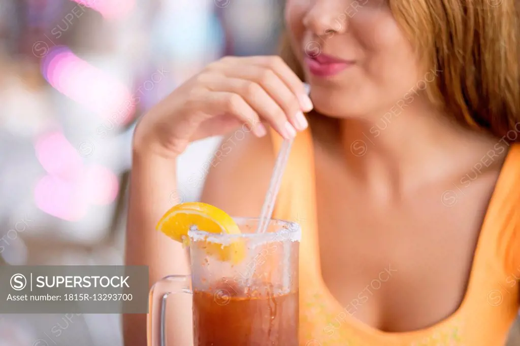 Teenager enjoying a michelada drink