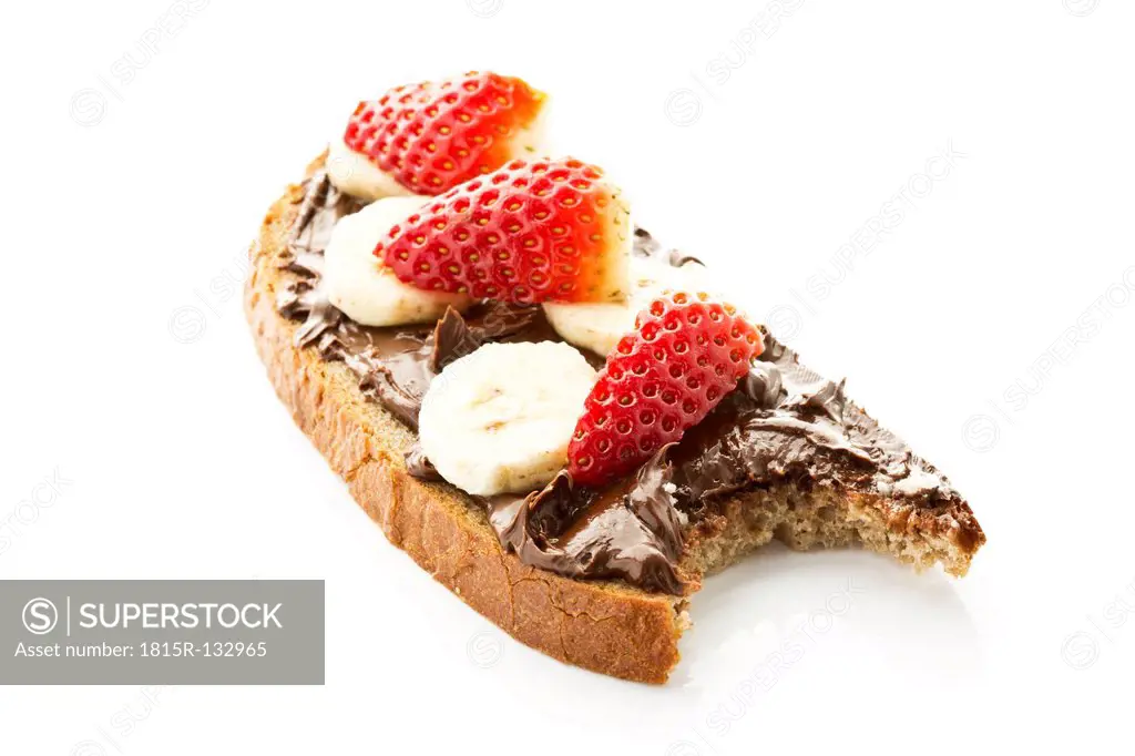 Bread topped with nutella, banana and strawberry slices, close up