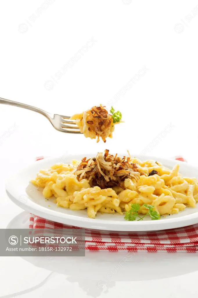 Plate of spaetzle with cheese and roasted onions, close up