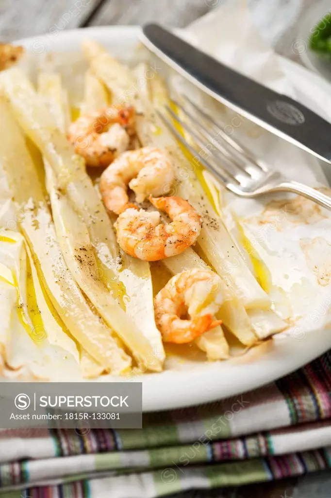 King prawns with white asparagus on plate, close up