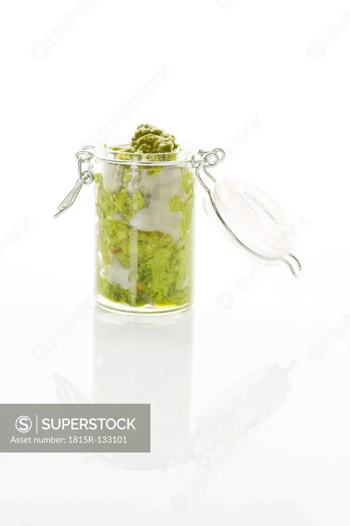 Basil Pesto in jar on white background, close up