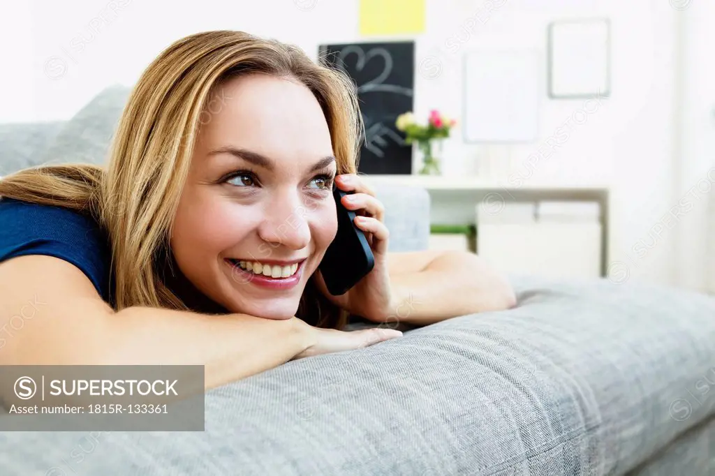Germany, Bavaria, Munich, Young woman talking on mobile phone, smiling