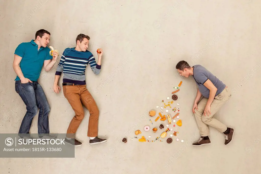 Men eating food against beige background