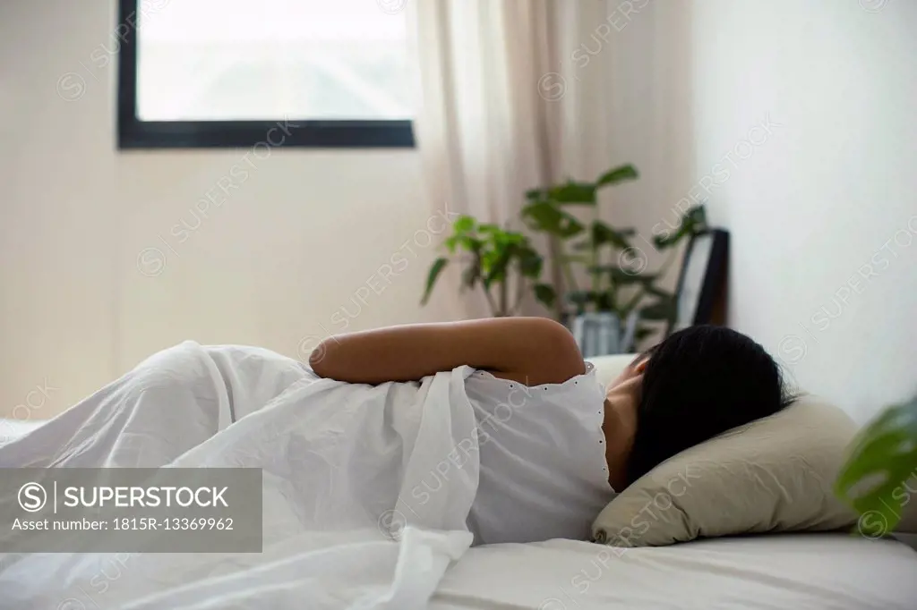Young woman lying in bed