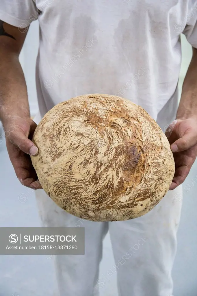 Baker holding a freshly baked bread