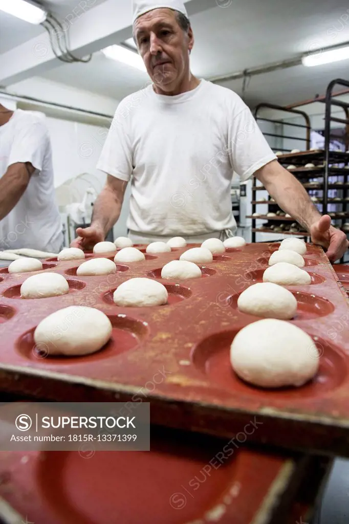 Doughs in hamburger bread molds before baking in a bakery