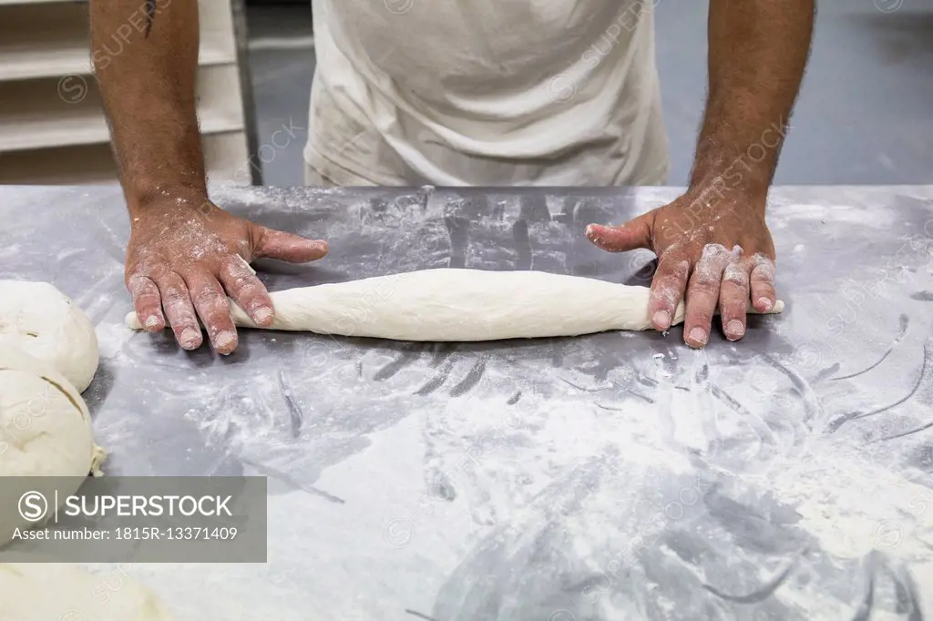Hands of baker kneading bread dough