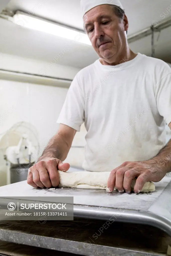 Baker kneading bread in a bakery