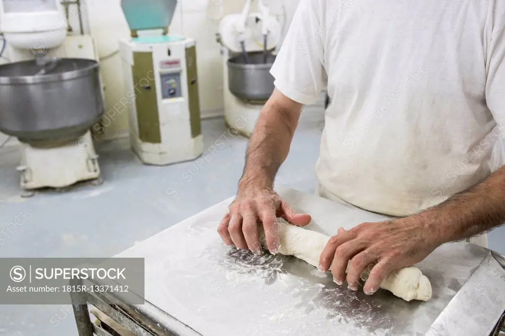 Hands of baker kneading bread dough