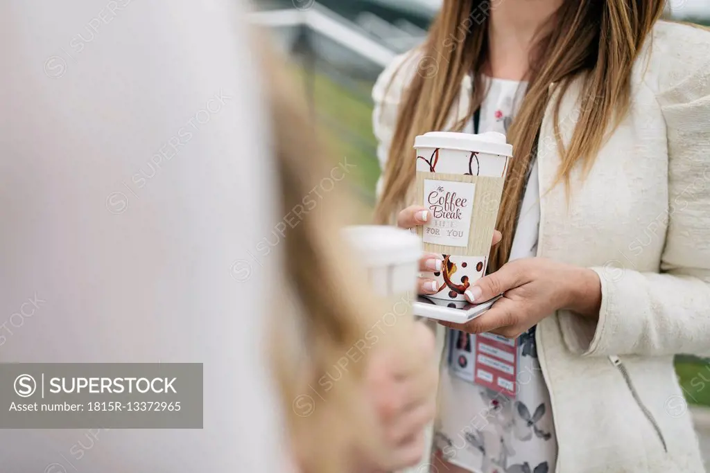 Two women having coffee break outdoors