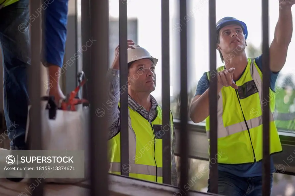 Men with reflective vests talking on construction site