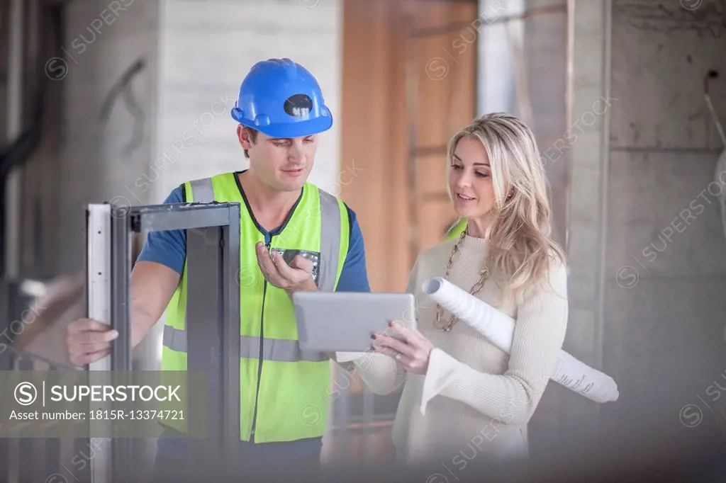 Construction worker talking to woman on construction site