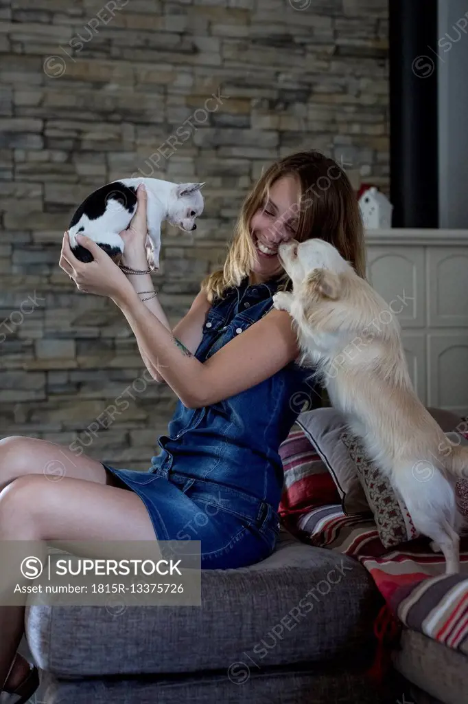 Smiling woman with her dogs at home