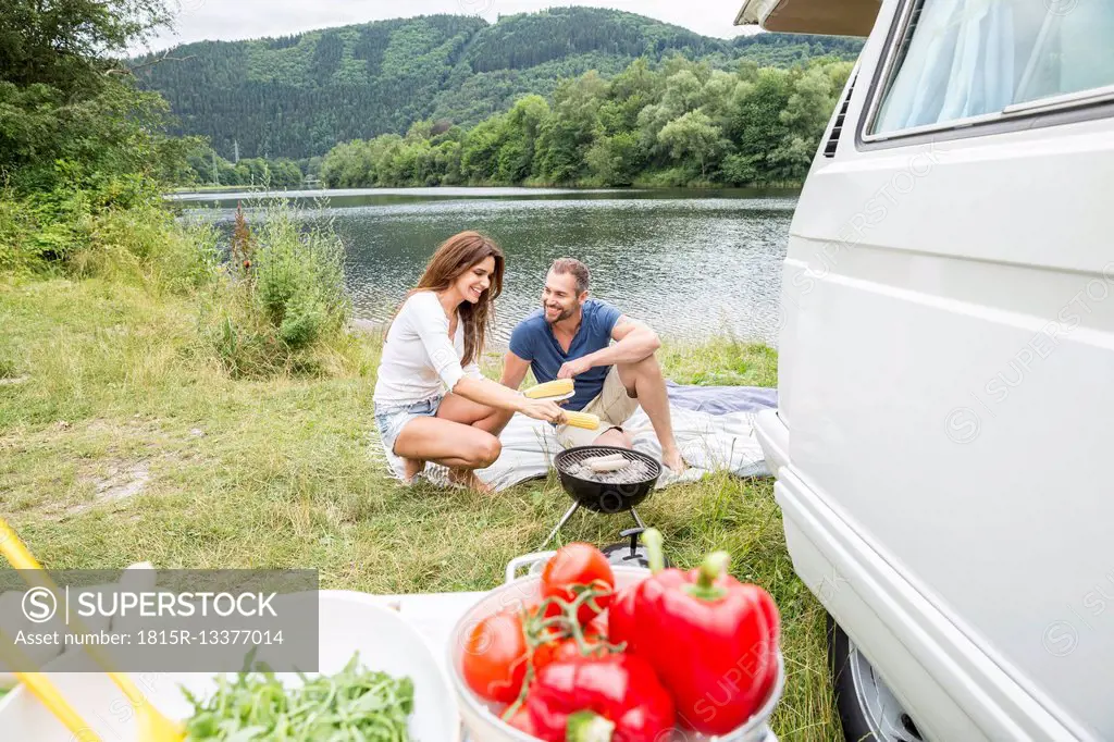 Couple having a barbecue at lakeside