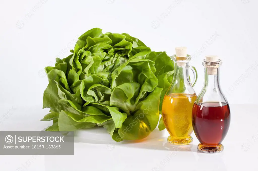 Lettuce with vinegar and olive oil on white background, close up