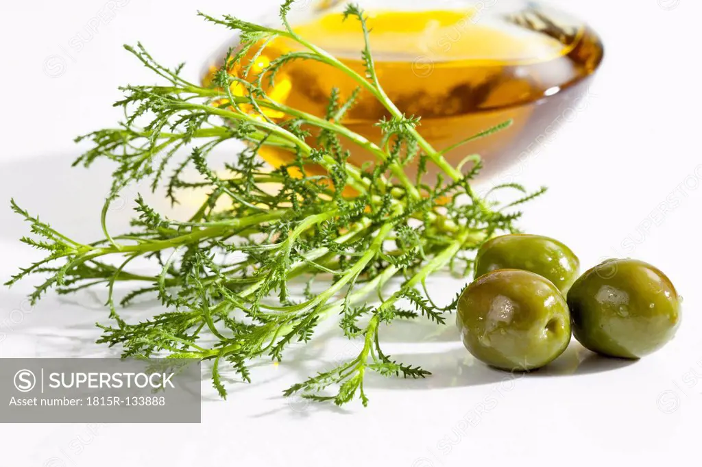 Olive herb with olives and olive oil on white background, close up