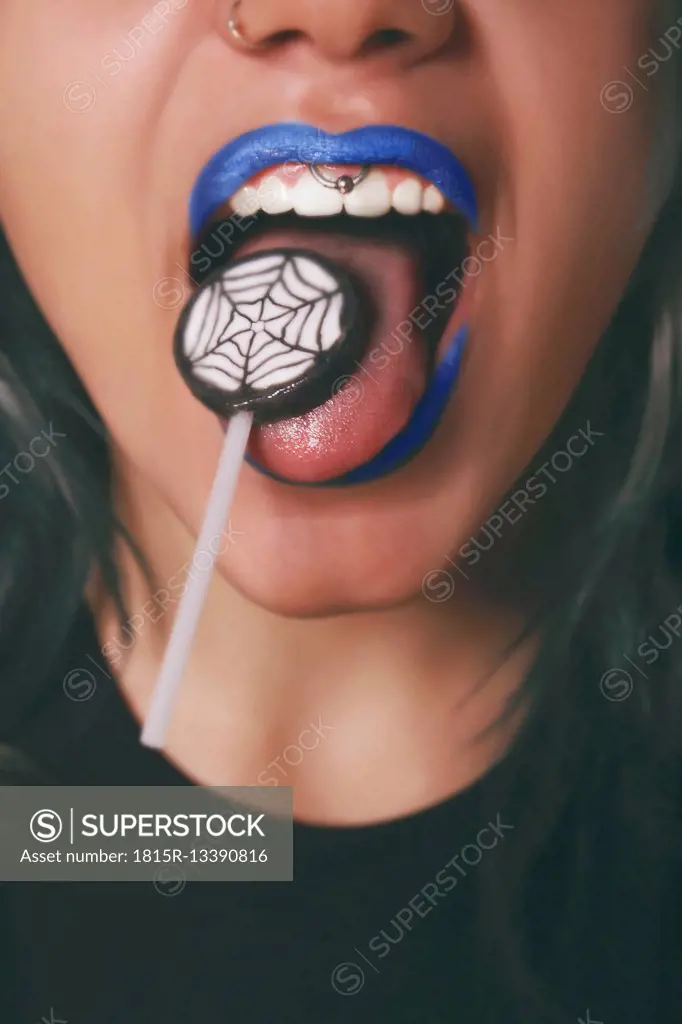 Woman licking Halloween lollipop, close-up