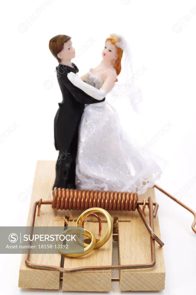 Wedding couple figurines standing on mouse trap, close-up