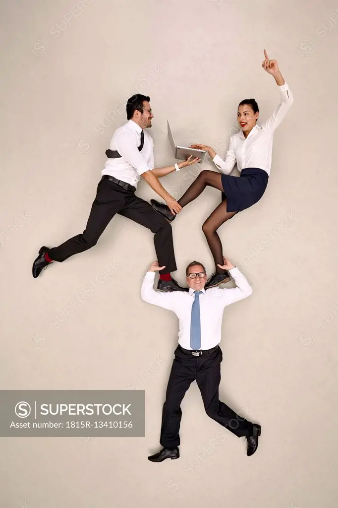 Businessman carrying his two male colleagues on his shoulders