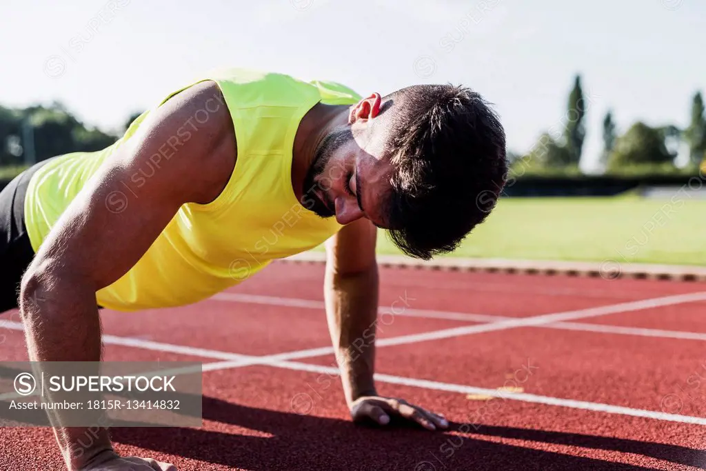 Athlete doing pushu-ups on tartan track
