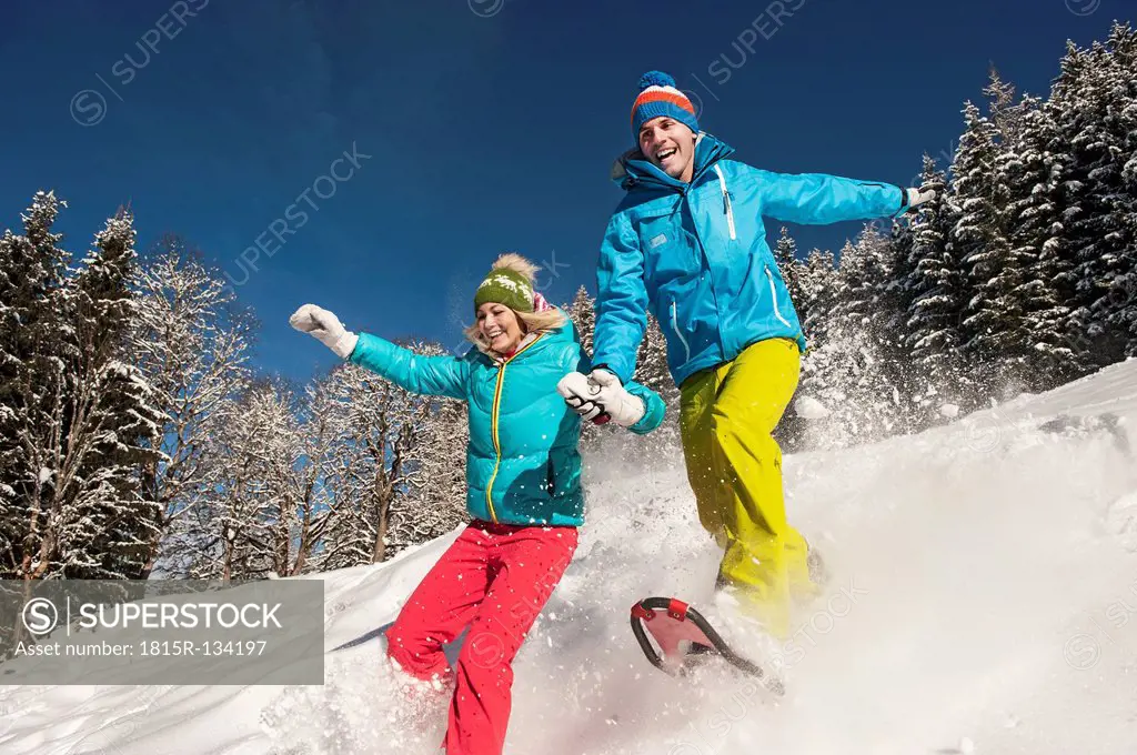Austria, Salzburg, Young woman and man snowshoeing at Altenmarkt Zauchensee
