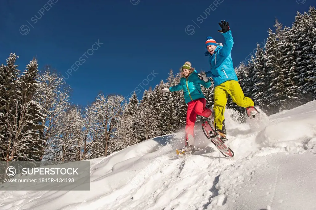 Austria, Salzburg, Young woman and man snowshoeing at Altenmarkt Zauchensee