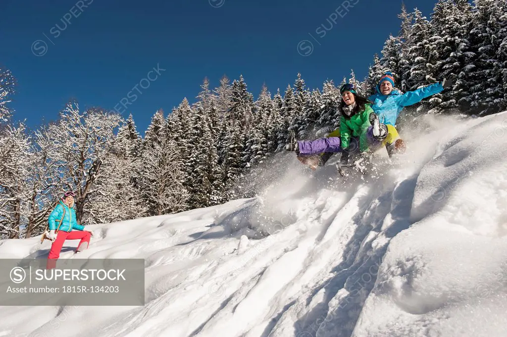 Austria, Salzburg, Young man and women with sledge in snow at Altenmarkt Zauchensee