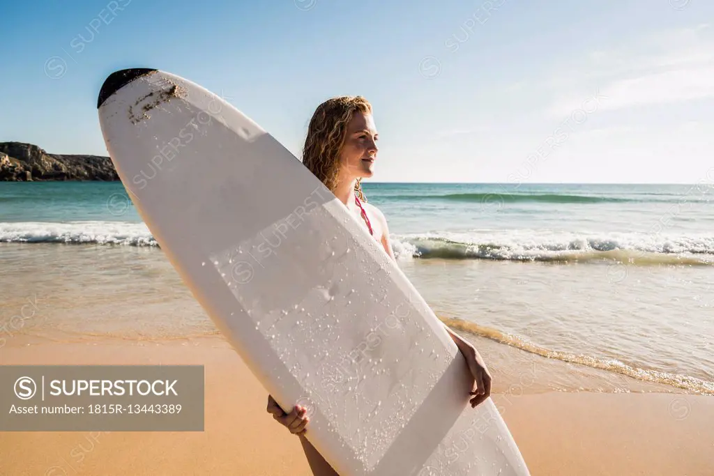 Teenage girl holding surfboard at the sea