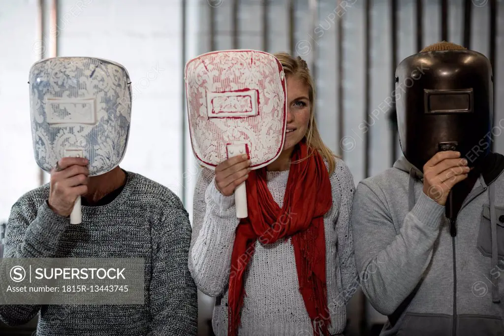 Three people hiding behind designer masks