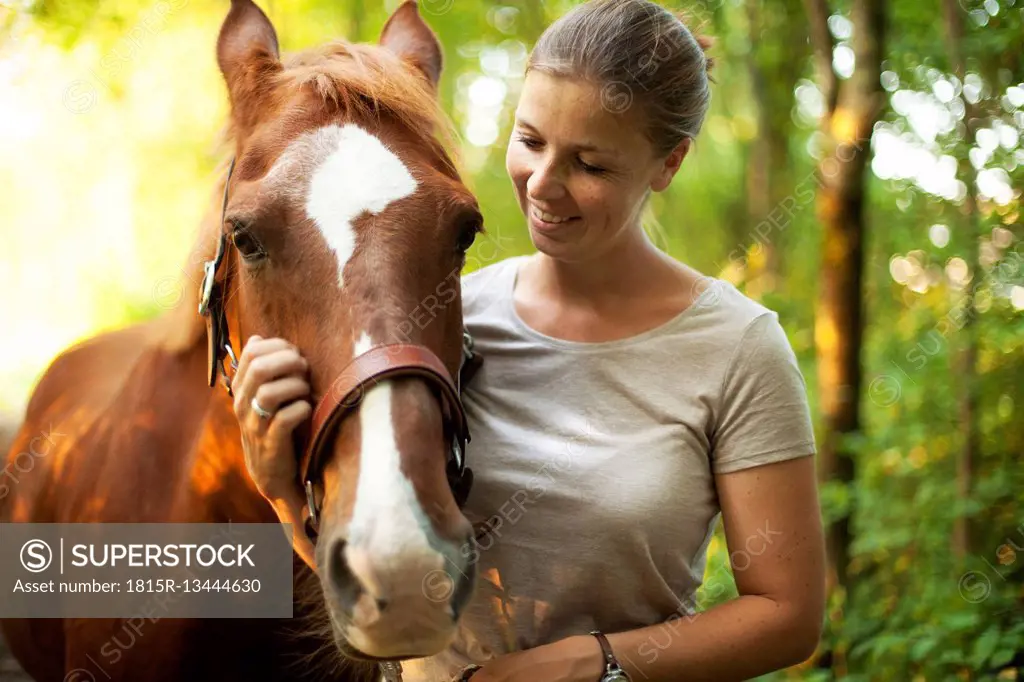 Smiling young woman with horse