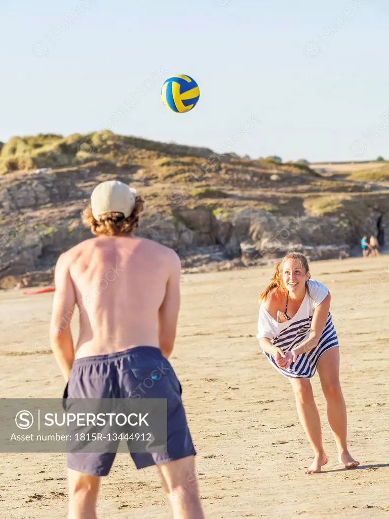 Couple at the beach playing volleyball