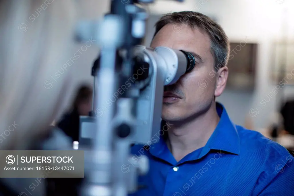 Optometrist doing eye test with patient