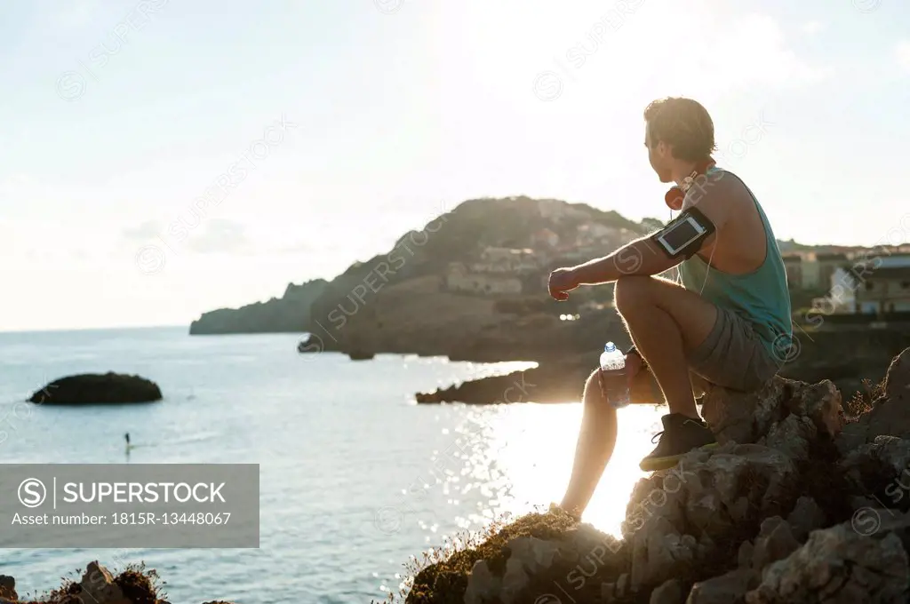 Spain, Mallorca, Jogger with water bottle at the beach
