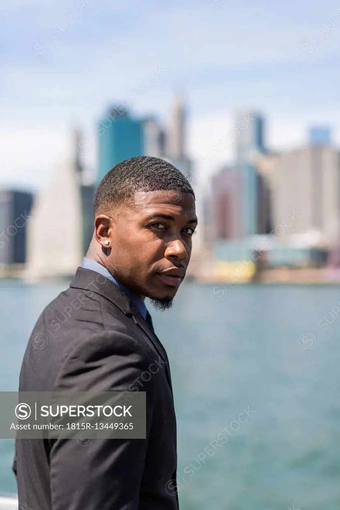 USA, Brooklyn, portrait of businessman in front of Manhattan skyline