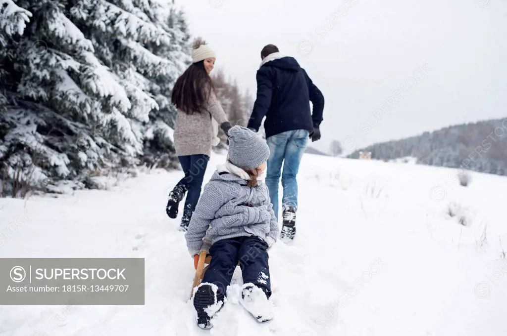 Family with sledge in winter landscape