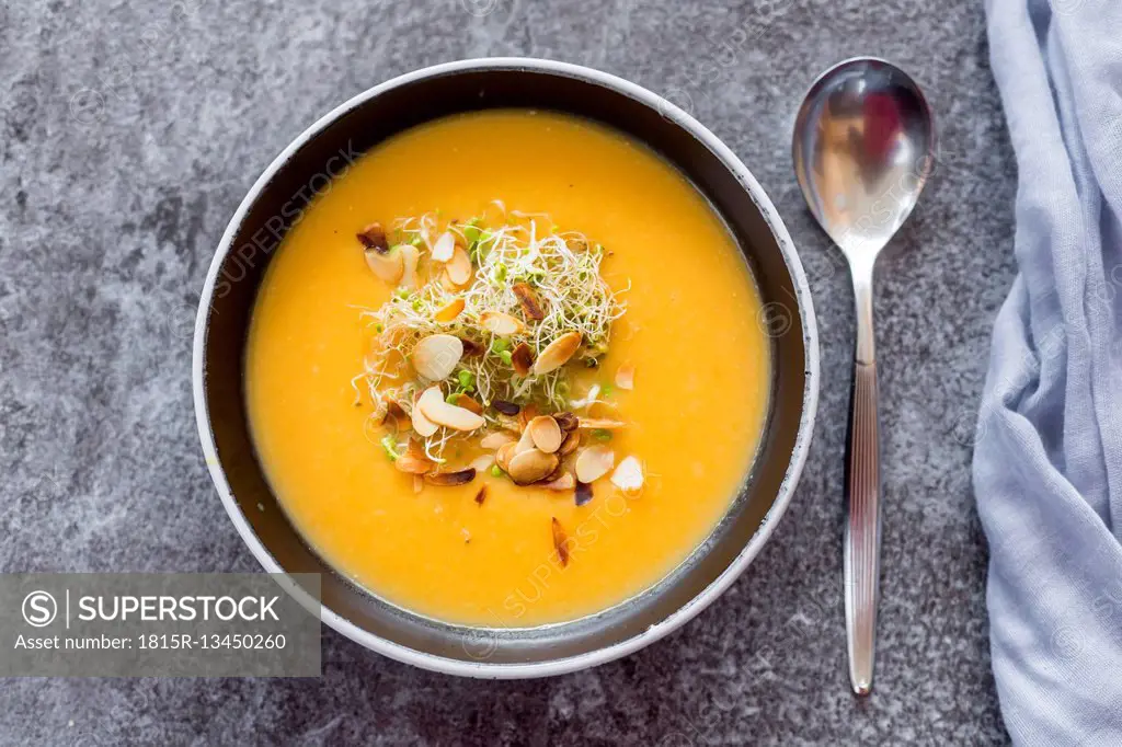 Bowl of sweet potato coconut soup with ginger, parsnip, leek, sprout and almond