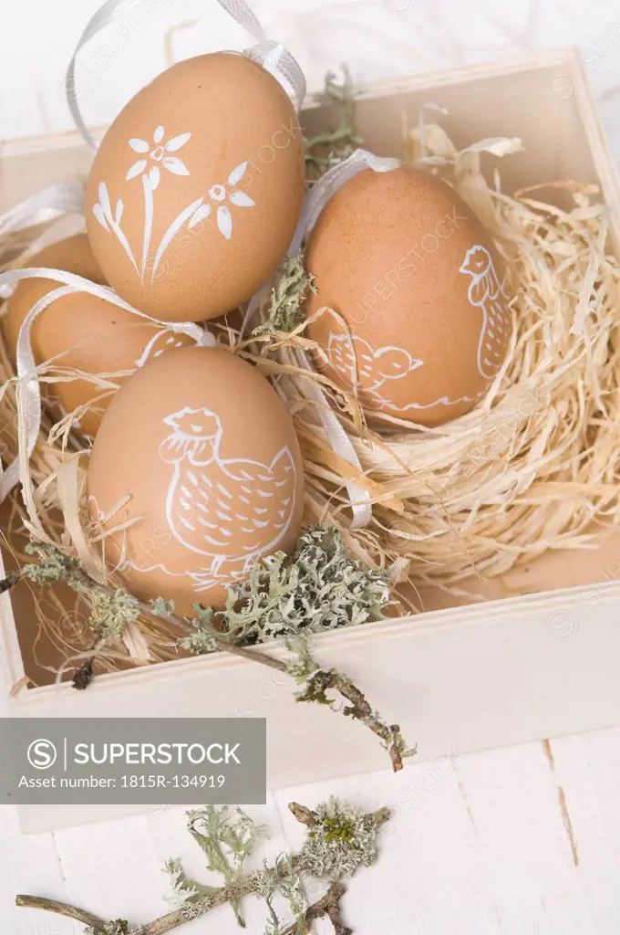 Painted easter eggs in box with straw