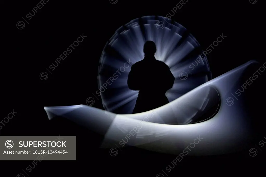 Shadow of a man painting with light