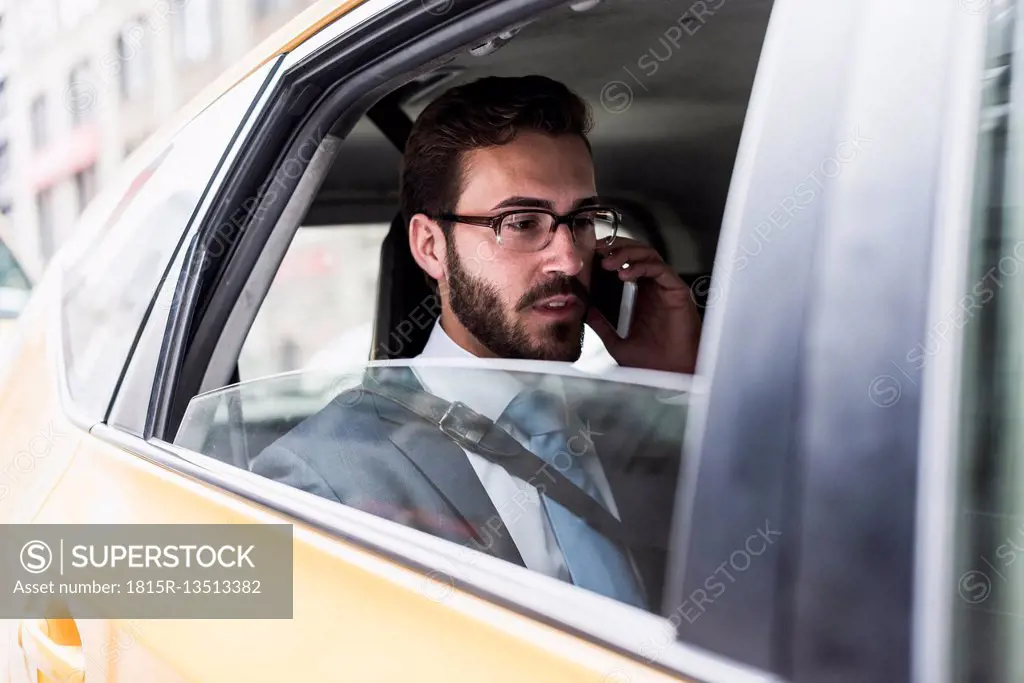 Businessman on cell phone in a taxi