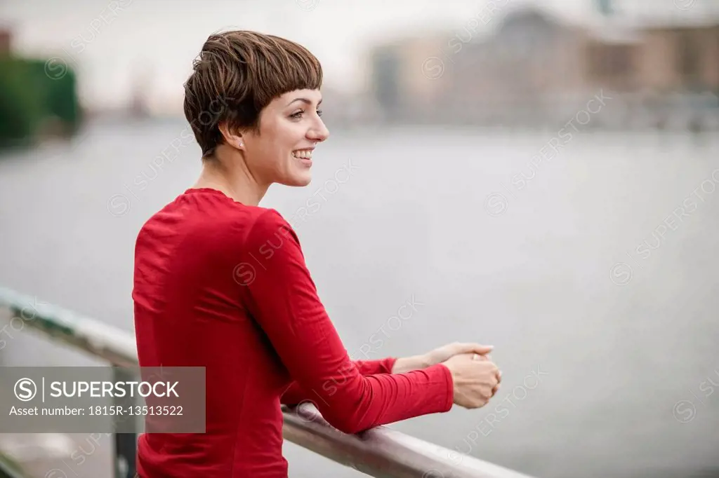 Smiling young woman wearing red shirt looking at distance