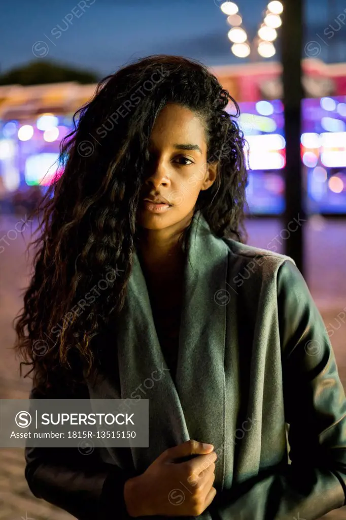 Portrait of a young woman on a funfair at night