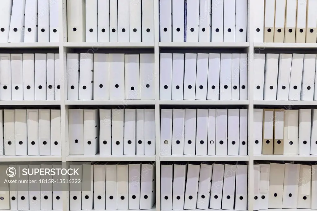 White shelf with rows of white folders