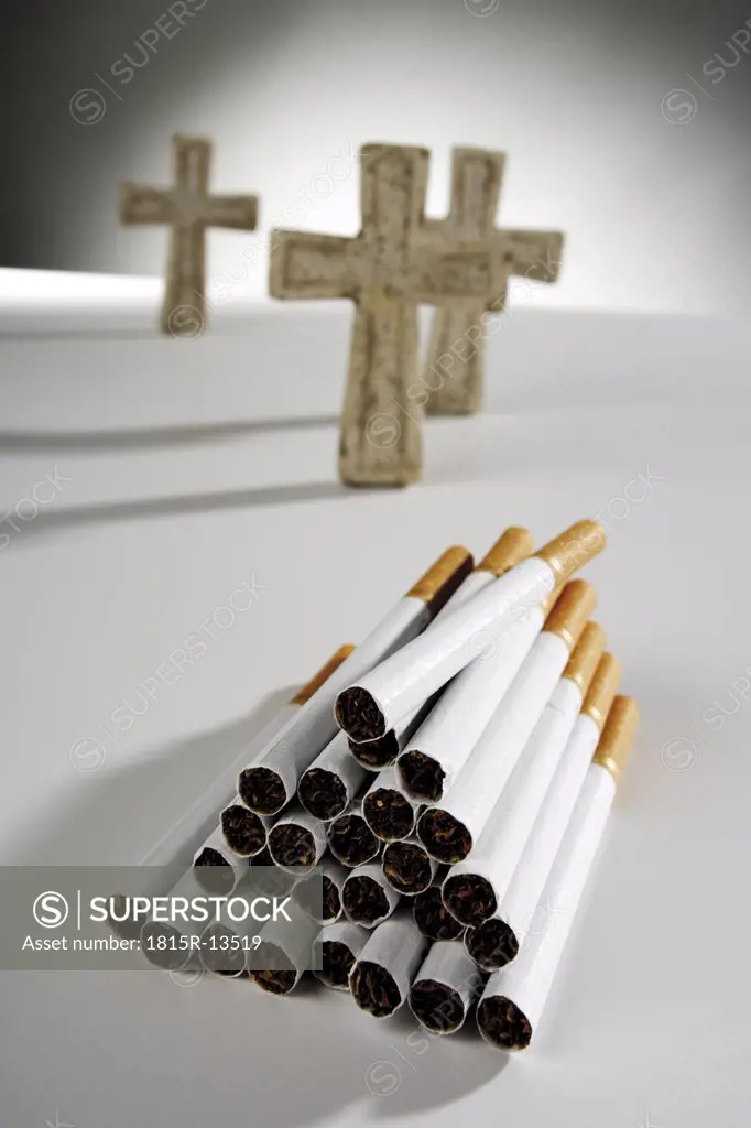 Pile of cigarettes, crosses in background, tilt view