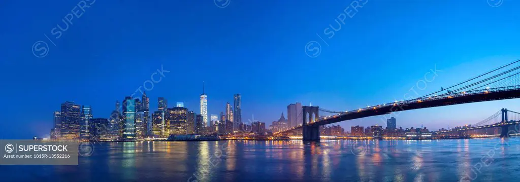 USA, New York City, Manhattan, panorama of financial district with Brooklyn Bridge at dawn