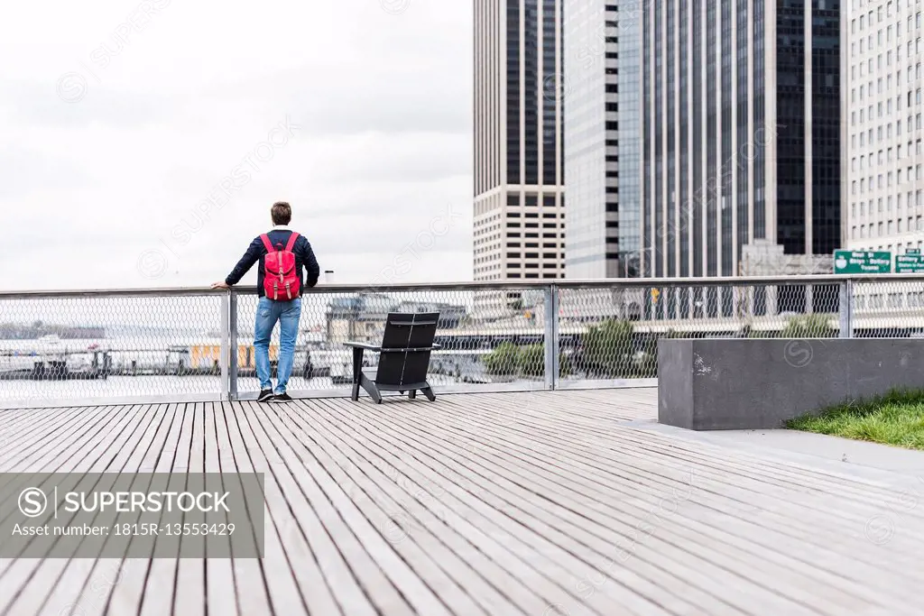 USA, New York, Man in Manhattan looking at skyscrapers
