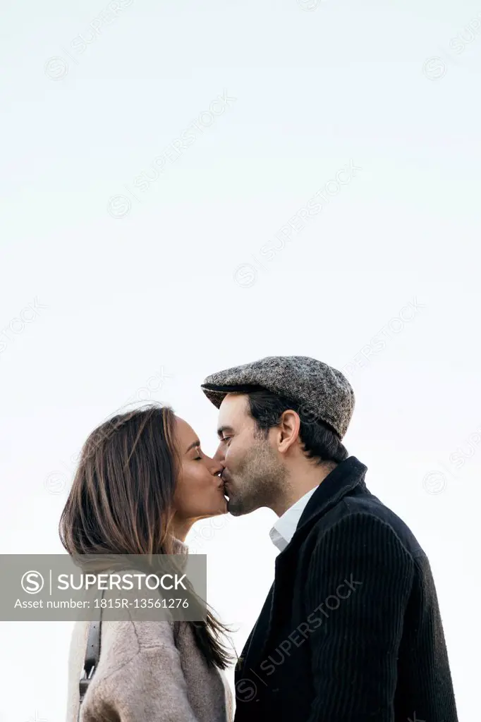 Couple kissing in front of sky