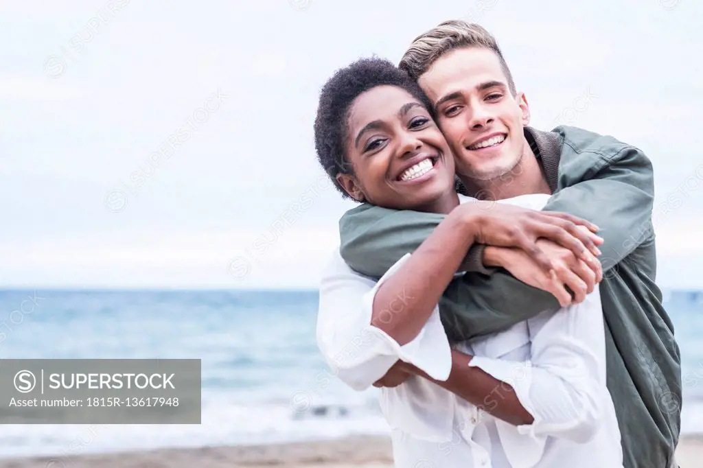 Happy young couple hugging on the beach
