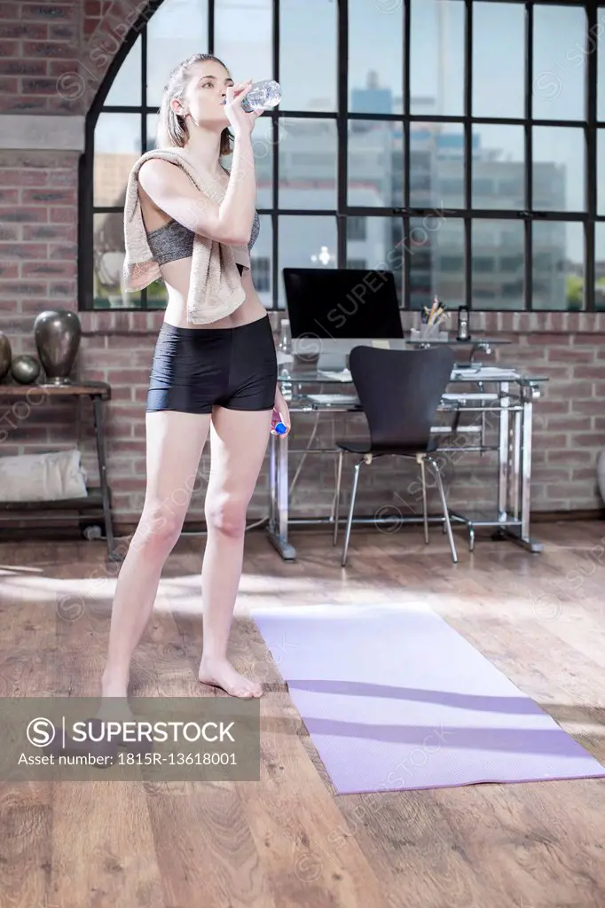 Young woman taking a refreshment break in exercise room