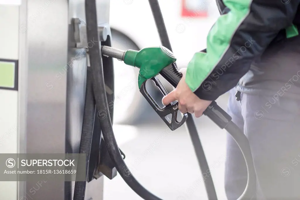Petrol attendant holding petrol pump