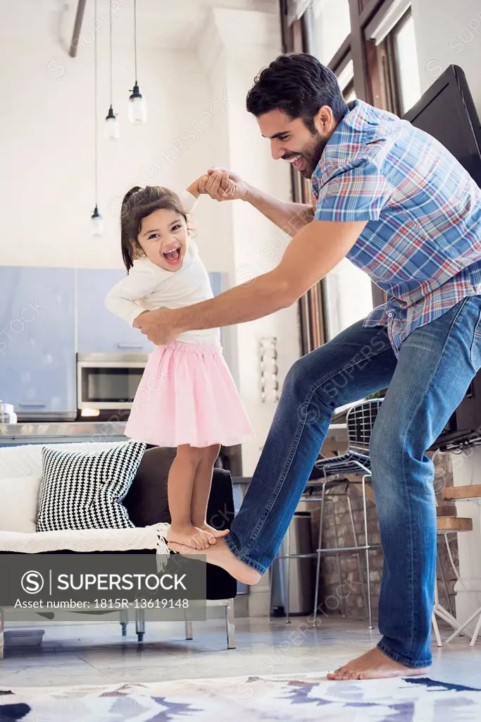 Father balancing his daughter on his foot